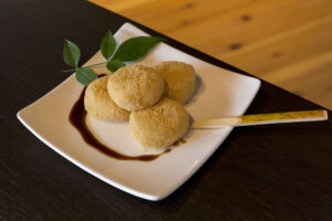 Japanese warabimochi dusted with kinako soybean flour, served with kuromitsu syrup