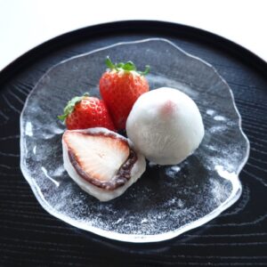 Strawberry daifuku cut in half to show the strawberry and red bean paste inside